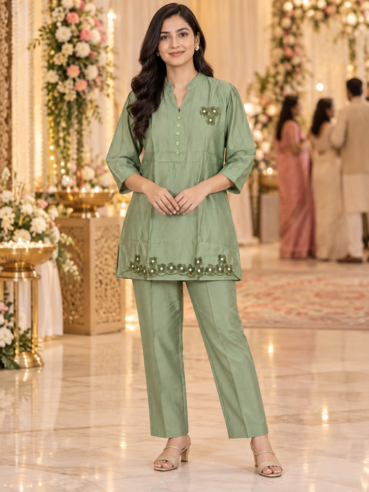 Sage-green Roman silk co-ord set for women with floral embroidery, reflective accents, scalloped kurta hem and matching straight pants.